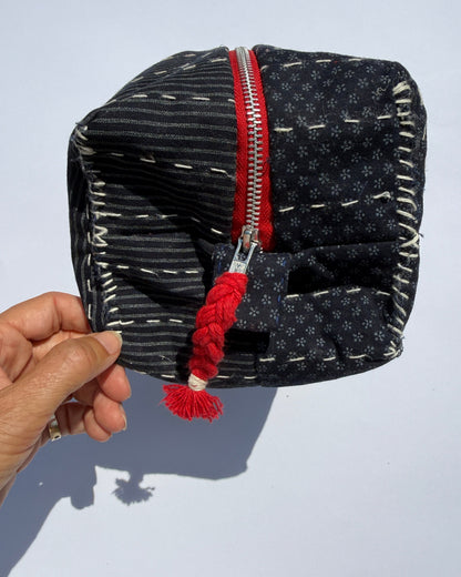 A handmade fabric metal zippered pouch with a dark navy and white Japanese fabric and quilted design.
